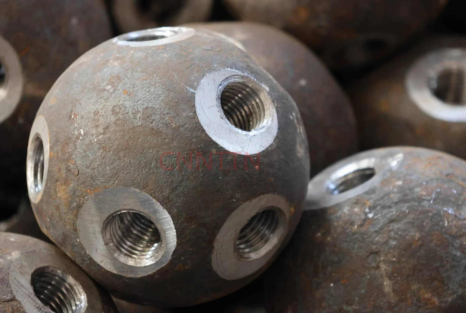 Close view of threaded openings in a steel ball node.